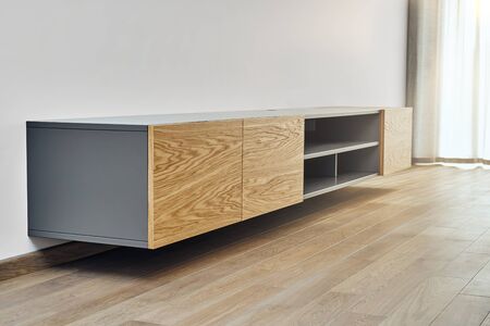 Contemporary floating media cabinet in living room. Wall mounted wooden cabinetの写真素材