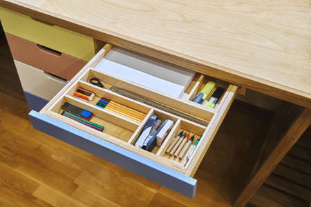 Ready for school. Open desk drawer with various school supplies arranged carefully in order before...