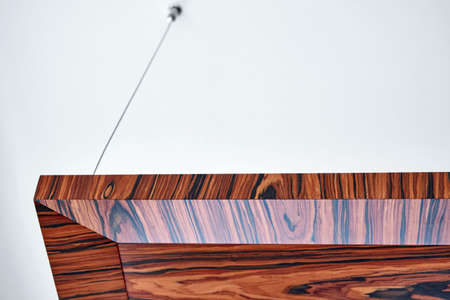 Wooden ceiling panels. Rosewood fineline veneer ceiling panels in the modern office. Close-up
