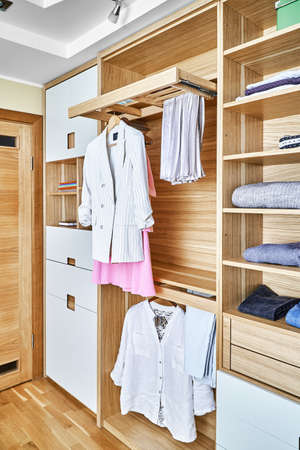 Internal details of the wooden wardrobe with slide out rack for coathangers. Modern wardrobe with...