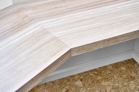 Elegant writing desk made with bleached solid oak timber mounted on white wall, close upper viewの写真素材