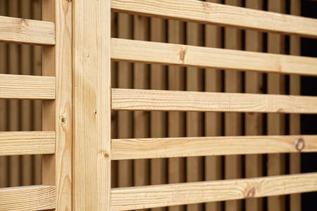 Stylish decorative partition made of thin wooden planks stands on contemporary country house terrace...