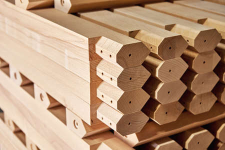 Huge stack of simple tables legs made of solid beechwood material stands in contemporary carpentry...