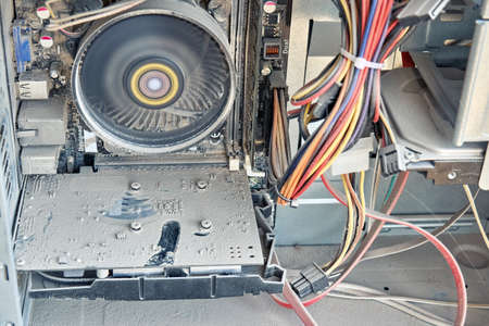Closeup of a opened dusty old computer is covered with a thick layer of dust, standing on the floor...