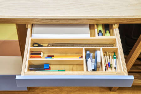 Table for children with multi-colored facades of roll-out drawers for stationery. Sawhorse desk made...