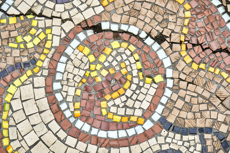 Old cracked mosaic attracts scientists and tourist attention with durability over years. Racks on stone mosaic wall have historical significance closeupの写真素材