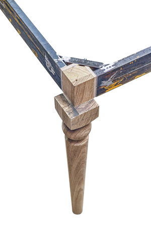 Wooden carved leg of solid oak with metal table frame during manufacturing process of dining table isolated on white backgroundの写真素材