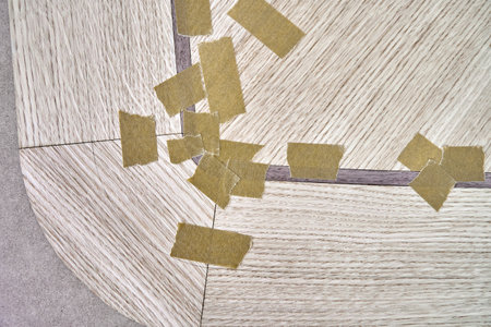 Jointed veneer with tape into canvas for table top of dining table with geometric pattern on workbench in workshop upper close viewの写真素材