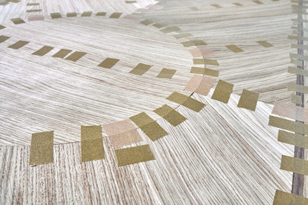 Jointed veneer with tape for table top of dining table with geometric pattern on workbench in workshop closeupの写真素材