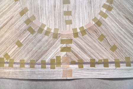 Jointed veneer with tape into canvas for table top of dining table with geometric pattern on workbench in workshop upper close viewの写真素材