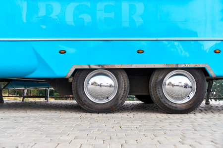 Wheels with shiny disks of large blue food truck on city street. Vehicle with portable cafe for town visitors. Large car providing fast foodの写真素材