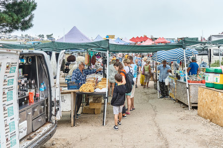 Gelendzhik, Russia - August 17, 2021: Traditional local market. Buyers choose farmer food product visiting country market. People sell agricultural goods to customers on fairのeditorial素材