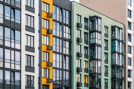 Contemporary residential buildings with vibrant facades, glass balconies, and large dark-framed windows, modern urban architecture designの写真素材
