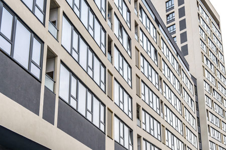 Modern building facade with large dark-framed windows and ventilation panels, showcasing clean architectural lines. Urban architecture conceptの写真素材