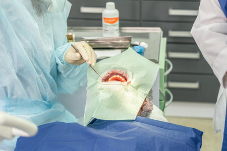 Two dental professionals perform a procedure on a patient in a clinical environment, focused and attentive to detailsの写真素材