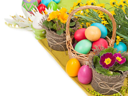 Easter eggs in a basket, flowers isolated on white background