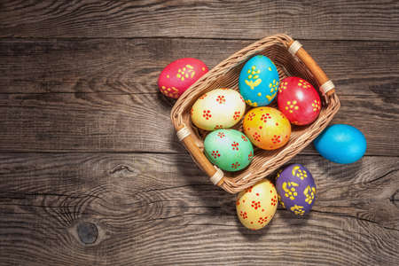 Easter eggs in basket of wooden boards.の写真素材