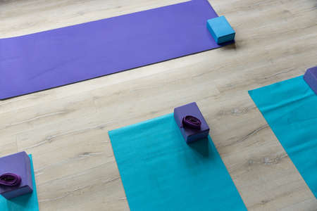 High angle view of exercise mats with blocks and belts placed on hardwood floor in yoga studioの写真素材