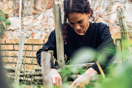 Portrait of beautiful female gardener working in vegetable garden at home