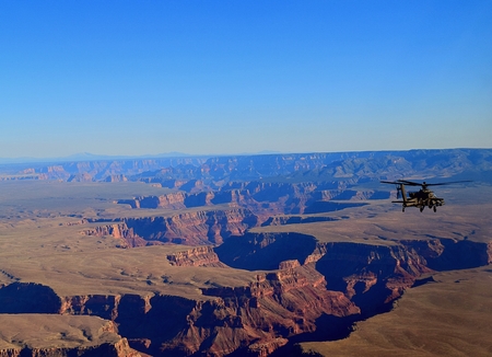 An attack helicopter flies over a large canyon in Arizona.の写真素材