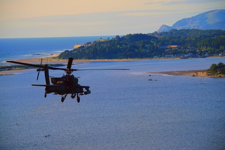 Attack helicopter flying over the ocean on Oregon's West Coast.の写真素材