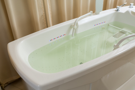 Empty bathtub, tub filled with water in the spa, backlitの写真素材