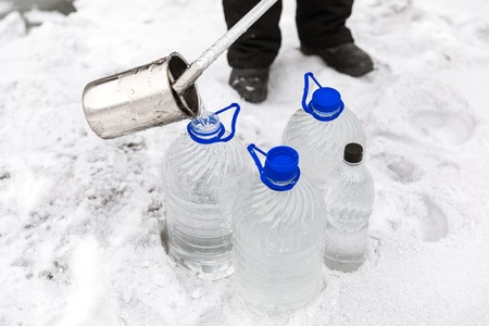 Man in special clothes collecting samples of water potentially contaminated by toxic material, in...