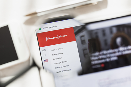 New York, USA - 4 March 2019: Johnson, JNJ, official website homepage under magnifying glass. Concept Johnson, JNJ logo visible on smartphone, tablet screen,のeditorial素材