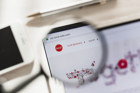 Los Angeles, California, USA - 4 March 2019: Coca-Cola Company official website homepage under magnifying glass. Concept Coca-Cola Company logo visible on smartphone, tablet screen,のeditorial素材