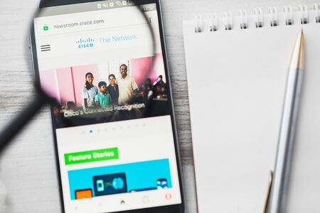 Los Angeles, California, USA - 3 April 2019: Cisco Systems Inc official website homepage under magnifying glass. Concept Cisco Systems, Inc. logo visible on tablet screen, smartphoneのeditorial素材