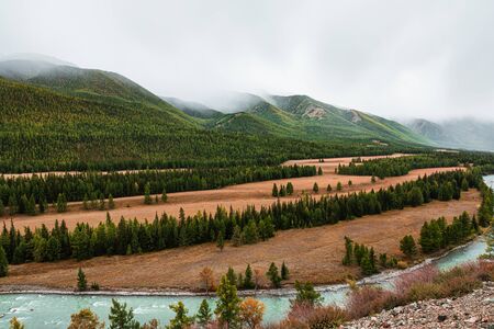 Panorama of mountain river on background of beautiful mountains in cloudy weather. View of turquoise river in the mountains on the background gloomy skyの写真素材