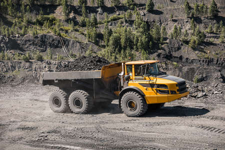 Large quarry dump truck. Loading the rock in dumper. Loading coal into body truck. Production useful...