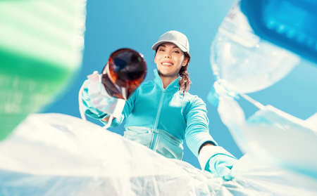 Happy girl holding package for garbage. Young woman volunteer, participates in an environmental...