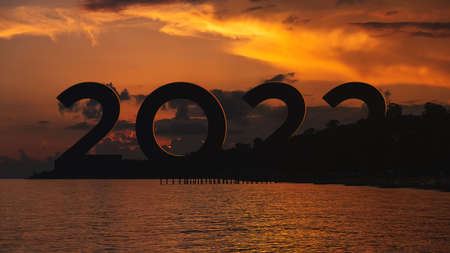 Concept of New 2022 growth and development prospects. Silhouette digits 2022 from behind the...