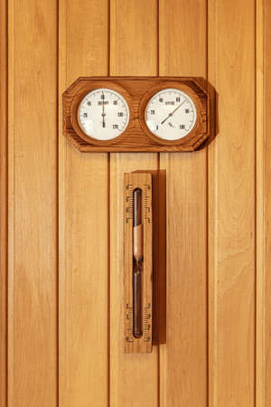Measurement of humidity and temperature. Interior of Finnish sauna, classic wooden sauna with hot steam. Russian bathroom. Hot sauna with steam. Wooden interior bath accessories for sauna, spaの写真素材