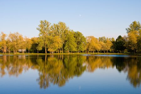 Park in the autumn. Reflexion in water, trees, the sky.の写真素材