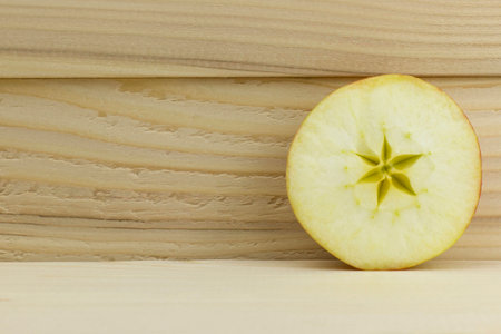 cut fresh juicy natural sour apple half on wooden backgroundの写真素材