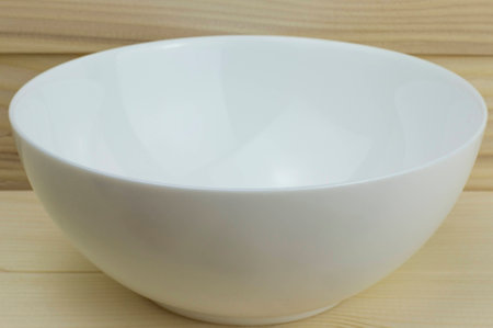 white shiny clean new plate on wooden backgroundの写真素材