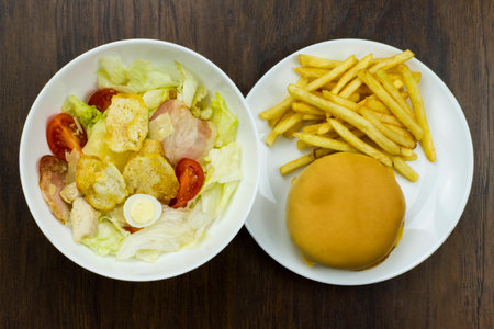 Caesar salad cheeseburger fries delicious healthy food tomatoes croutons Parmesan cheese and fresh mozzarella  junk food fast food cheese meat bad food not healthyの写真素材