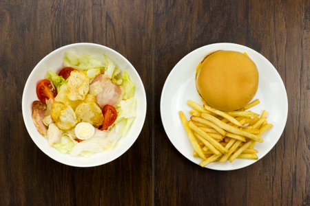 Caesar salad cheeseburger fries delicious healthy food tomatoes croutons Parmesan cheese and fresh mozzarella  junk food fast food cheese meat bad food not healthyの写真素材
