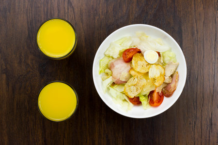 Caesar salad orange juice delicious healthy food tomatoes croutons Parmesan cheese and fresh mozzarellaの写真素材