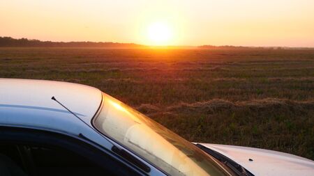 Novosibirsk, Russia, 28 august 2017, car Toyota Sprinter, Straw cornfields, sunset time with lens flareの写真素材