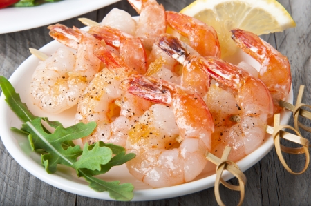 Fresh grilled shrimps with lemon on white plateの写真素材