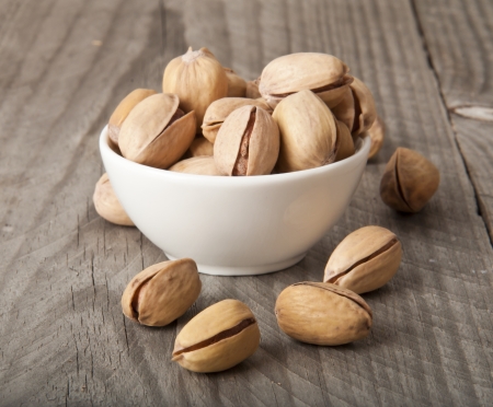 roasted pistachios on a natural wooden backgroundの写真素材