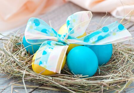 Easter eggs in nest on wooden background