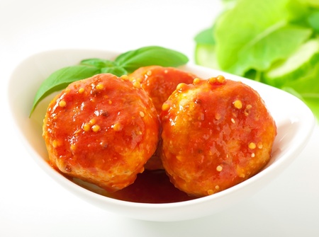 	meatballs in tomato sauce, decorated with leaves of basil