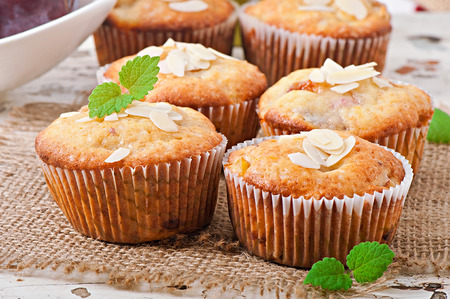 Muffins with plums and almond petals decorated with mint leavesの写真素材