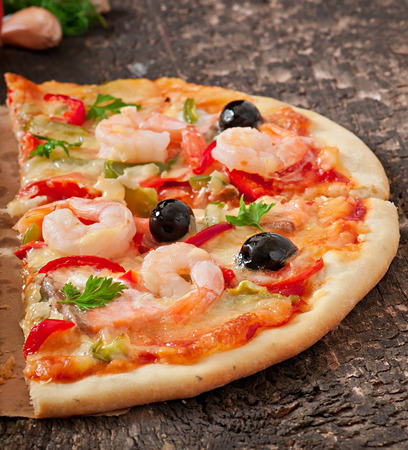 Pizza with shrimp, salmon and olivesの写真素材