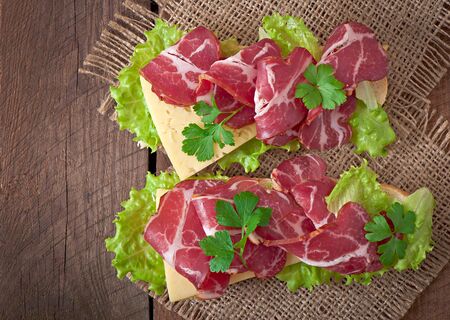 Big sandwich with raw smoked meat on a wooden backgroundの写真素材