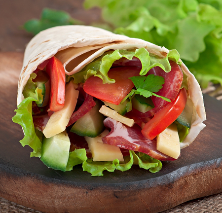 Fresh tortilla wraps with meat and vegetables on plateの写真素材
